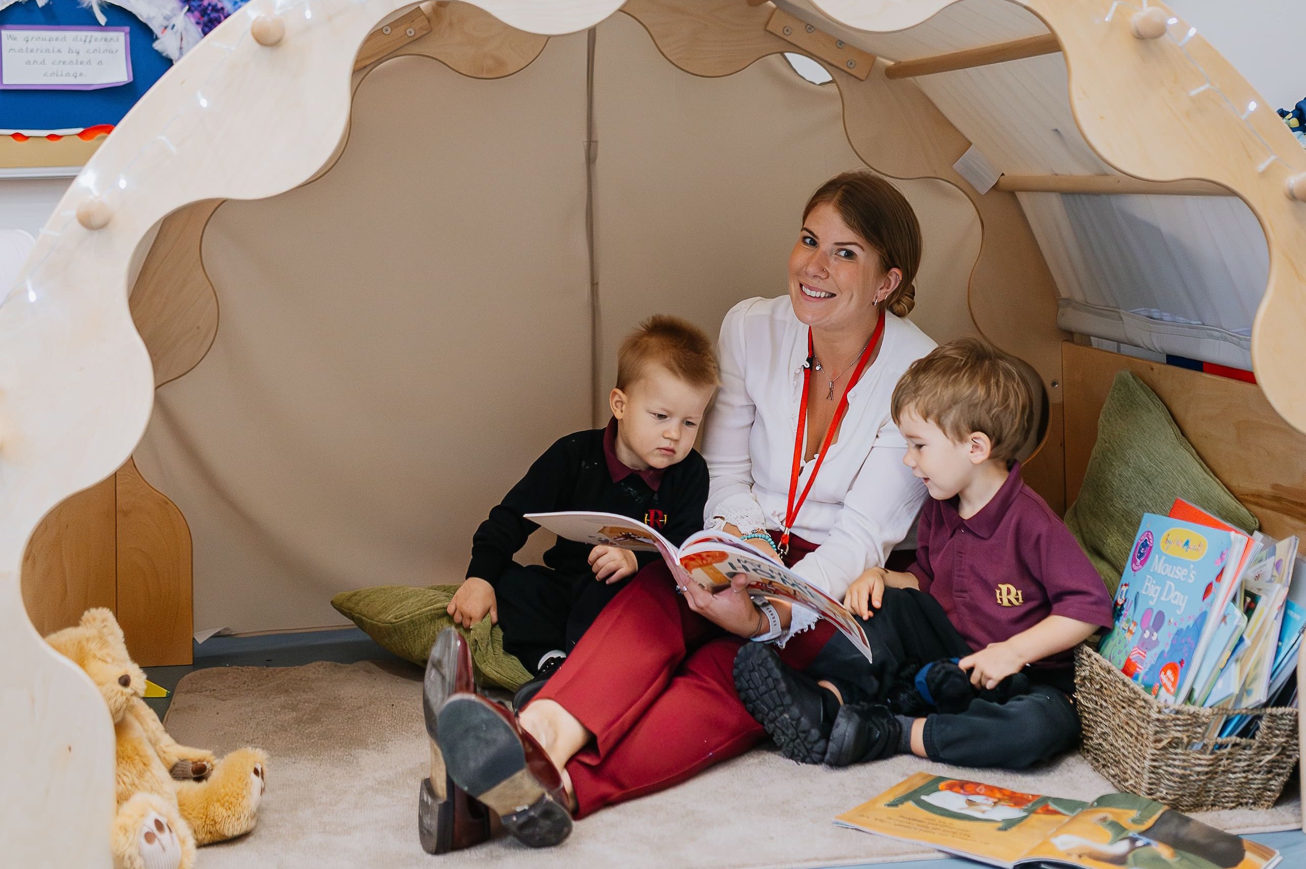 Teacher reading in indoor tent with two students